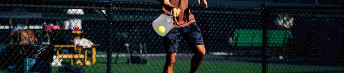 A guy is hitting a pickleball